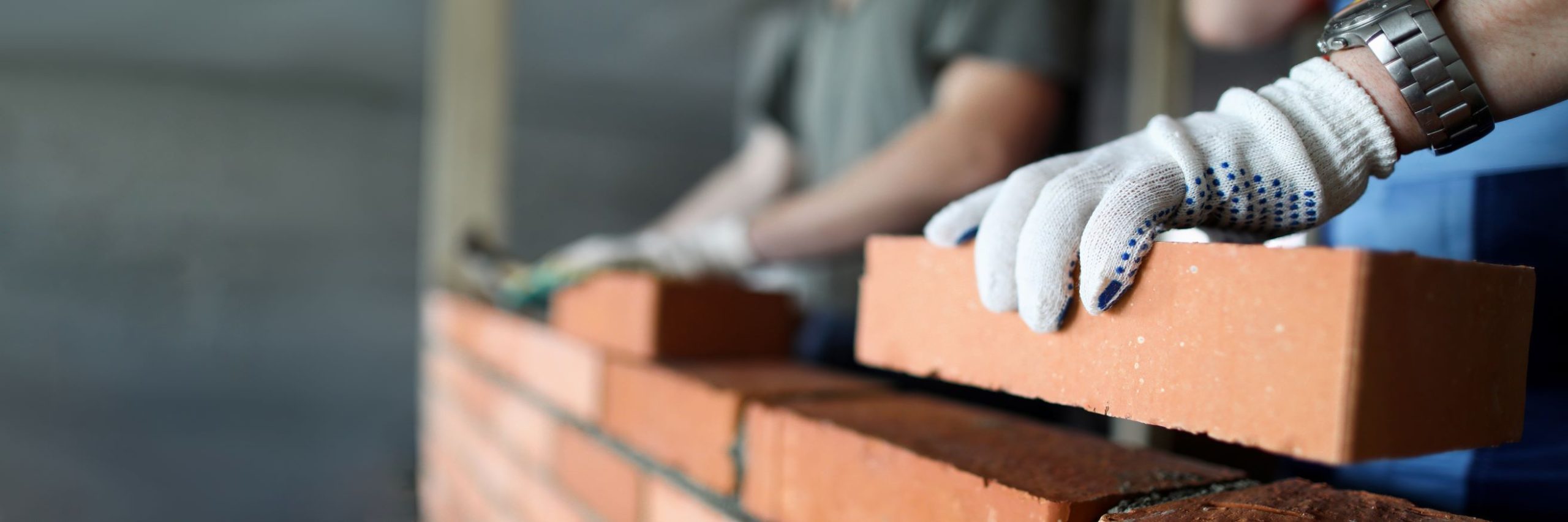 A mason using bricks in construction.