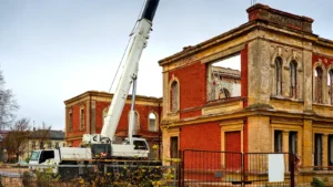 Restoration work on an old brick building with a crane and construction equipment at a historic site under renovation.