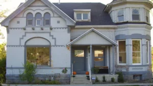 an image of house with bricks painted white before any restoration such as paint stripping, brick tuckpointing, or stone repair
