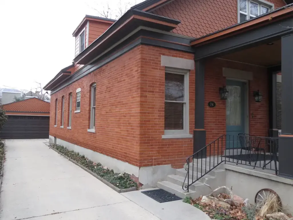 part of brick home that has had the paint removed to reveal the red coloring.