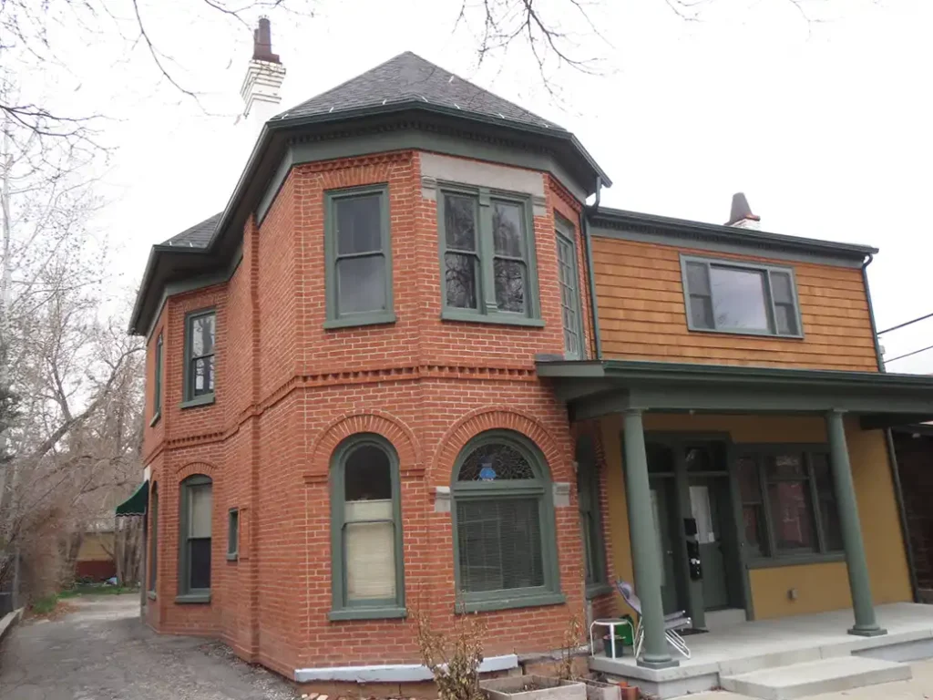 A 2-story brick home that's had paint removed to reveal the natural red coloring.