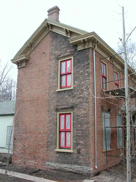 A 2-story brick home that's had half of the facade cleaned.